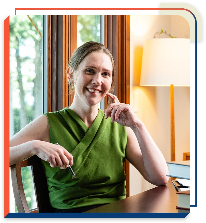 2 A woman sitting at the table with her hand on her chin.